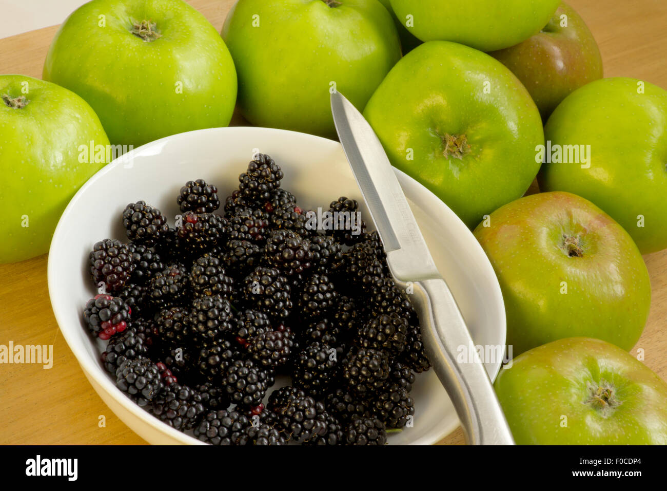 Freshly picked Blackberries in white bowl with Bramley Apples Stock Photo