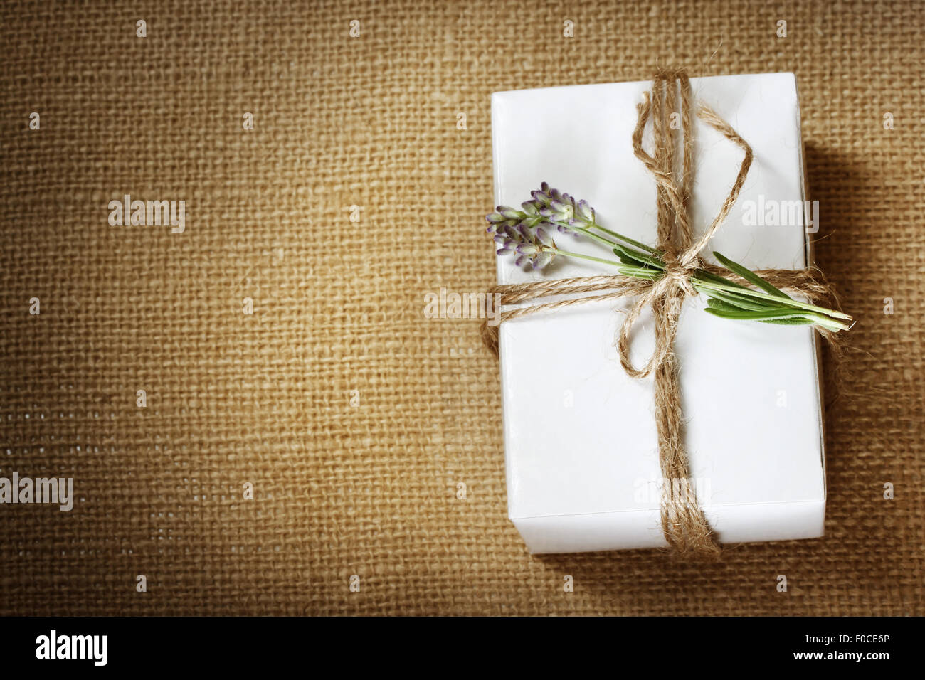 Homemade giftbox with lavender sprig on burlap cloth Stock Photo