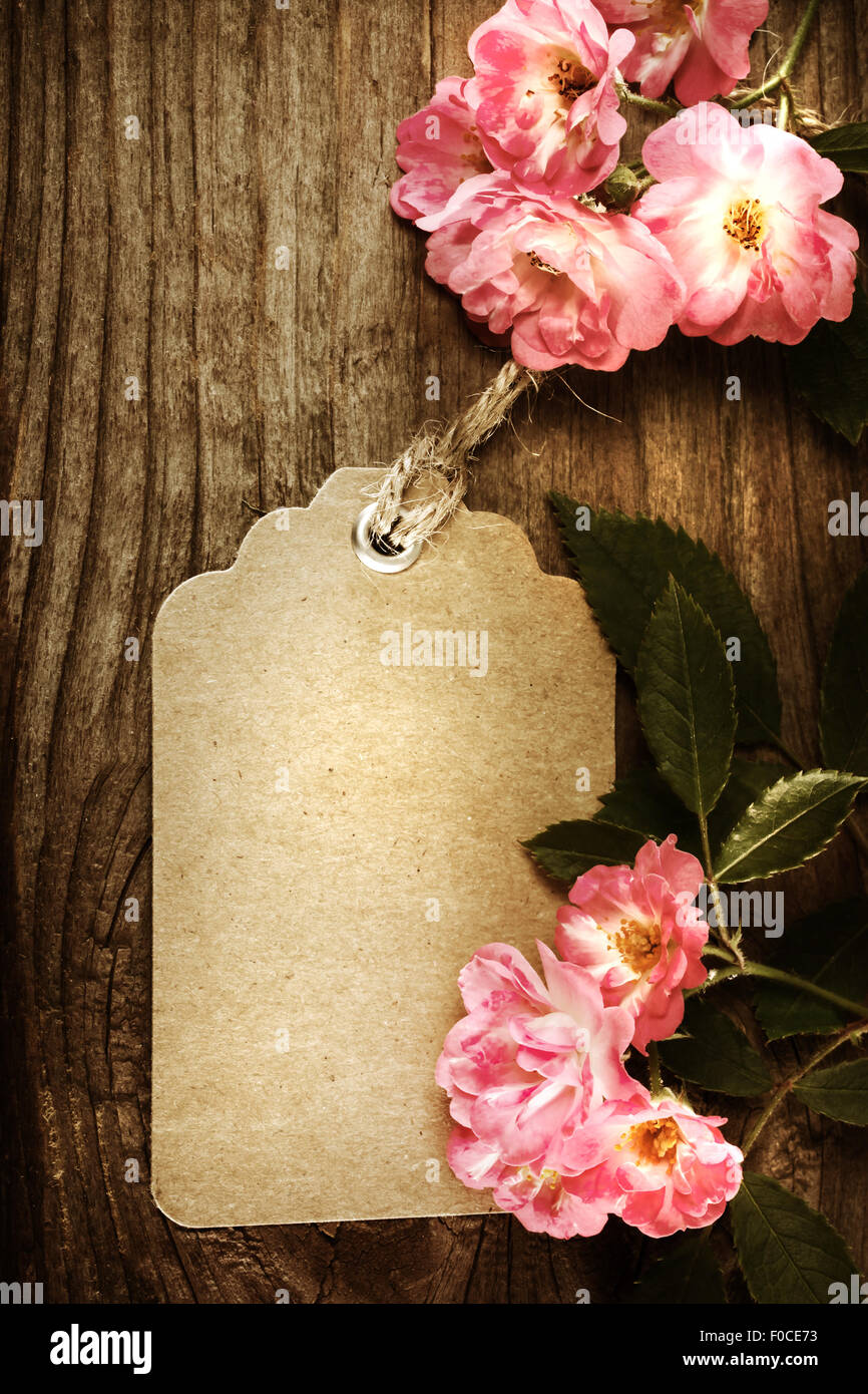 Handmade tag with robin hood roses on a rustic wooden table Stock Photo