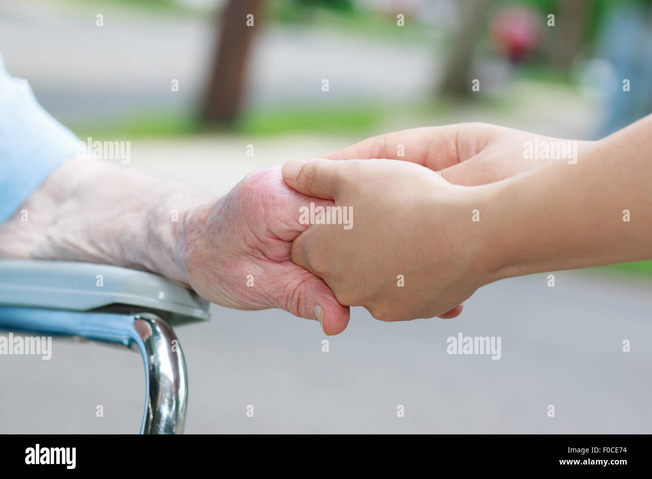 Caregiver holding an elderly womans hand outside Stock Photo