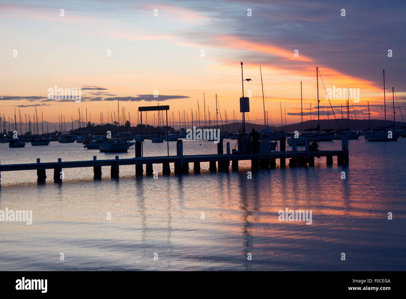 Boats and jetty at Belmont Lake Macquarie New South Wales NSW Australia at sunset Stock Photo