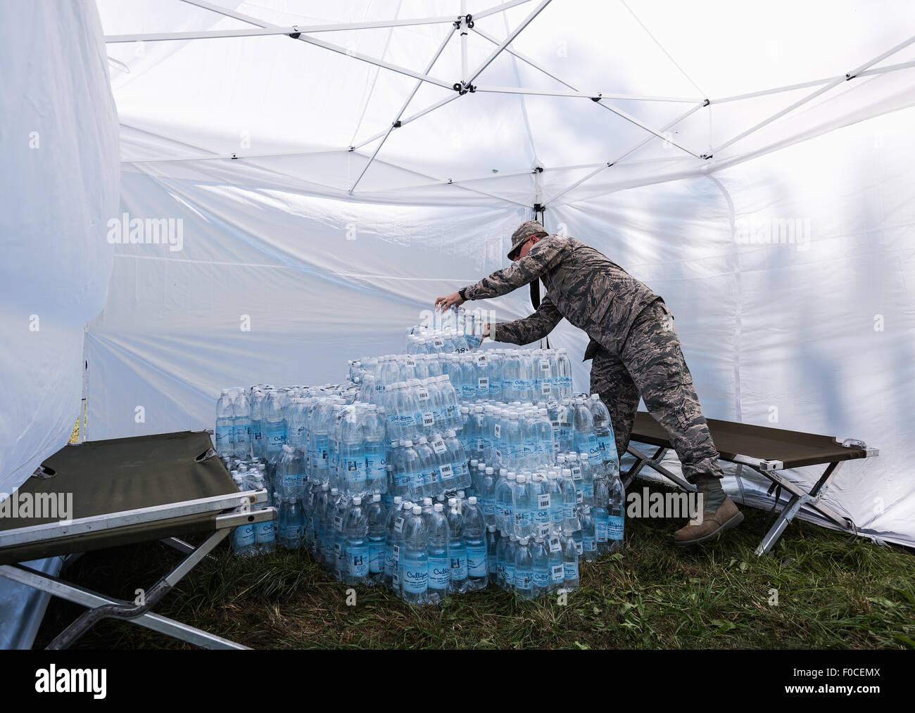 Engelmannsreuth, Germany. 12th Aug, 2015. A soldier of the US armed forces piles up water bottles in the aftermath of a crashed plane near Engelmannsreuth, Germany, 12 August 2015. A US Air Force F-16 crashed near Engelmannsreuth, Germany, on 11 August 2015. Rescue operations are still taking place. Photo: NICOLAS ARMER/dpa/Alamy Live News Stock Photo