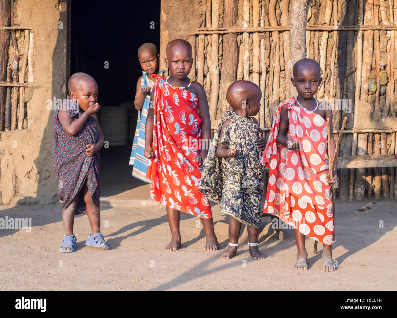 Maasai children in front of a traditional house in their boma (village) in Tanzania, Africa Stock Photo