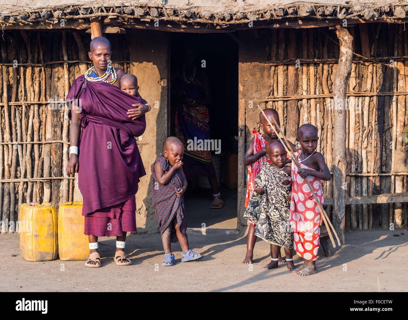 Maasai family in front of a traditional house in their boma (village) in Tanzania, Africa. Stock Photo