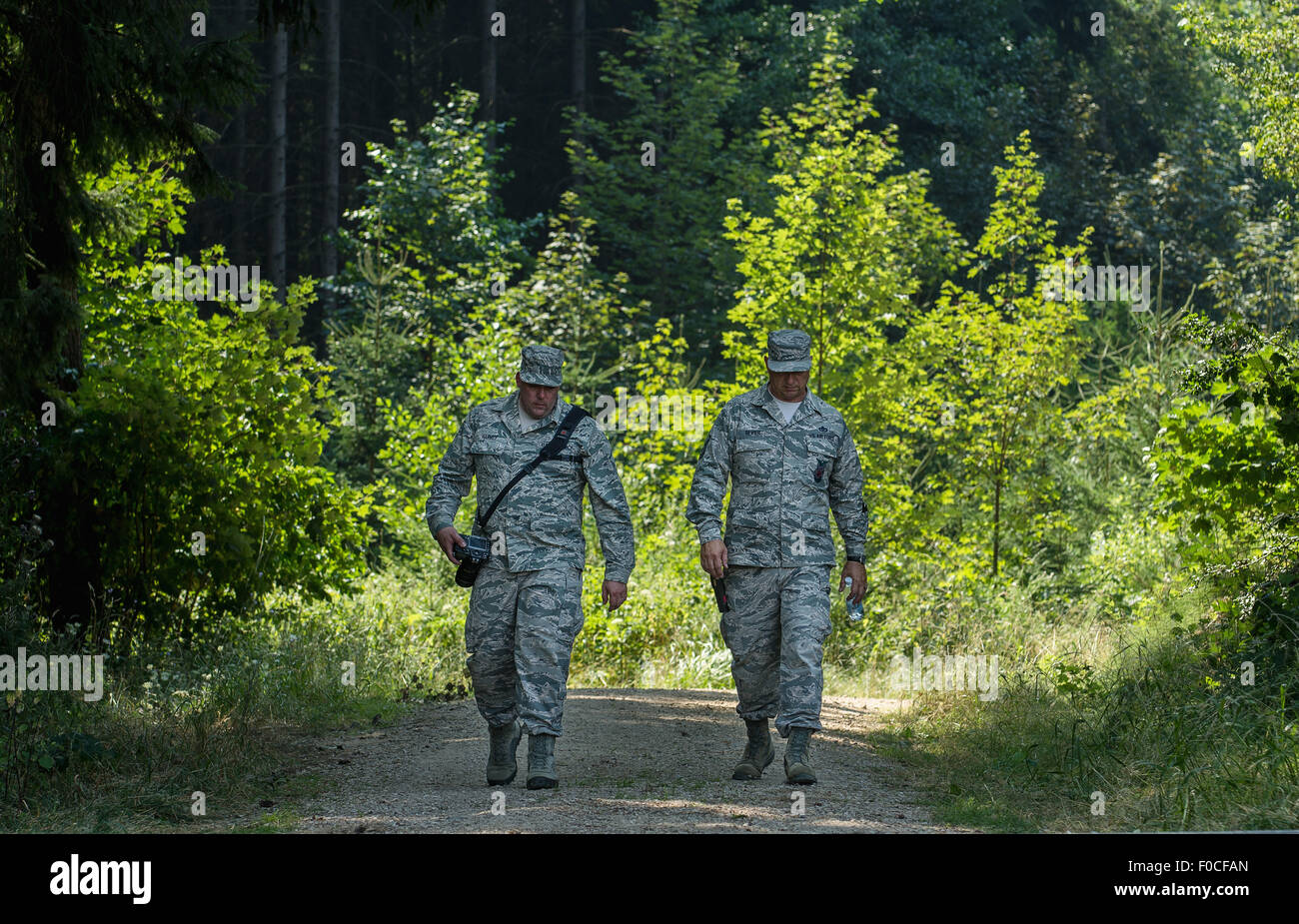 Engelmannsreuth, Germany. 12th Aug, 2015. Two soldiers of the US armed forces walk in a forest in the aftermath of a crashed plane near Engelmannsreuth, Germany, 12 August 2015. A US Air Force F-16 crashed near Engelmannsreuth, Germany, on 11 August 2015. Rescue operations are still taking place. Photo: NICOLAS ARMER/dpa/Alamy Live News Stock Photo
