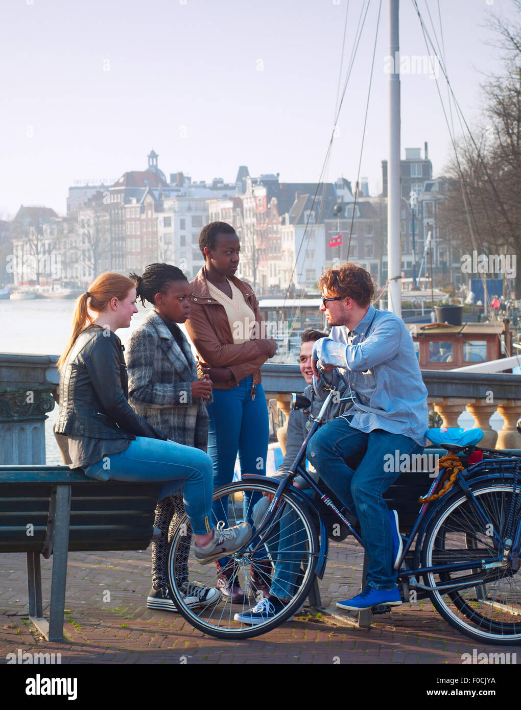 Multicultural friends in conversation on the street of Amsterdam. Stock Photo