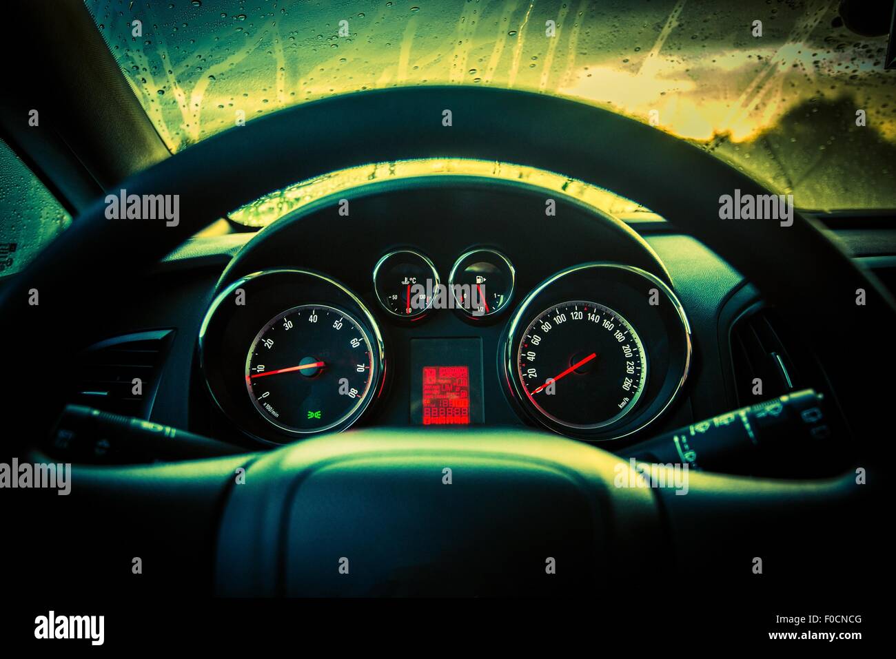 Modern Compact Car Dashboard Console and Steering Wheel Closeup. Rainy Weather. Stock Photo