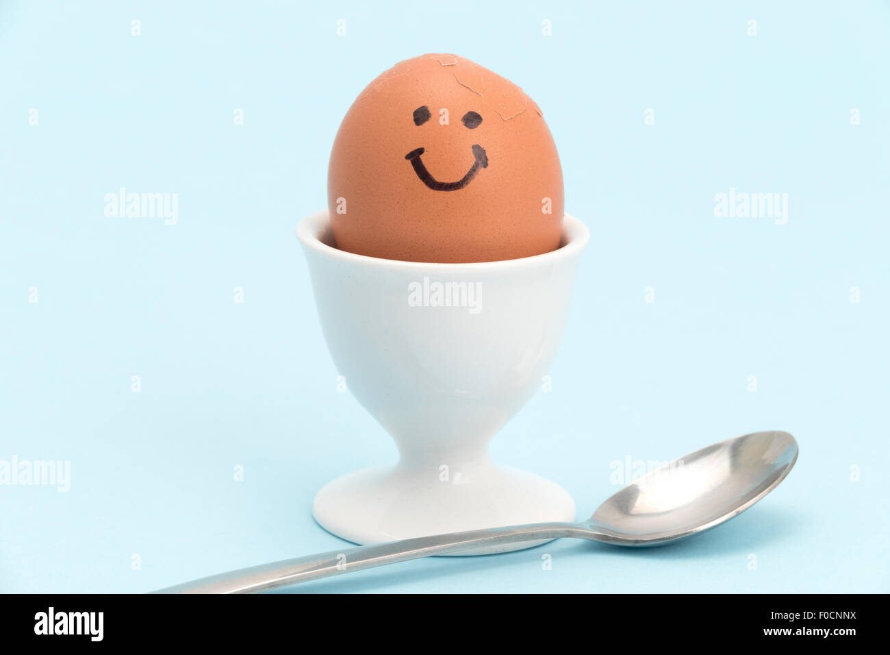 A boiled egg and teaspoon ready to eat - plain background Stock Photo