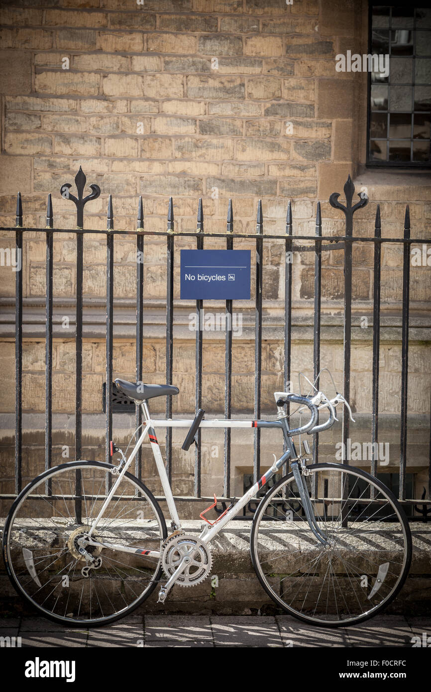 Bicyle tied to a fence  displaying NO Bicycle sign in Oxford, UK. Stock Photo
