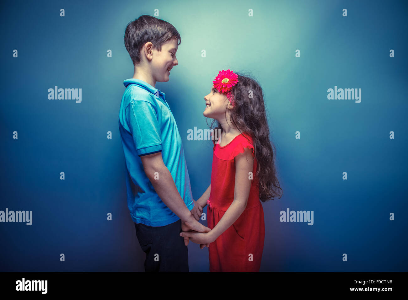 teen girl holding hands teenage boy on a gray  background retro photo effect Stock Photo