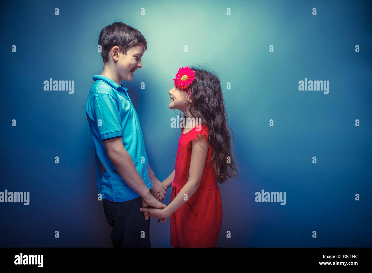 teen girl holding hands teenage boy on a gray background retro photo effect Stock Photo