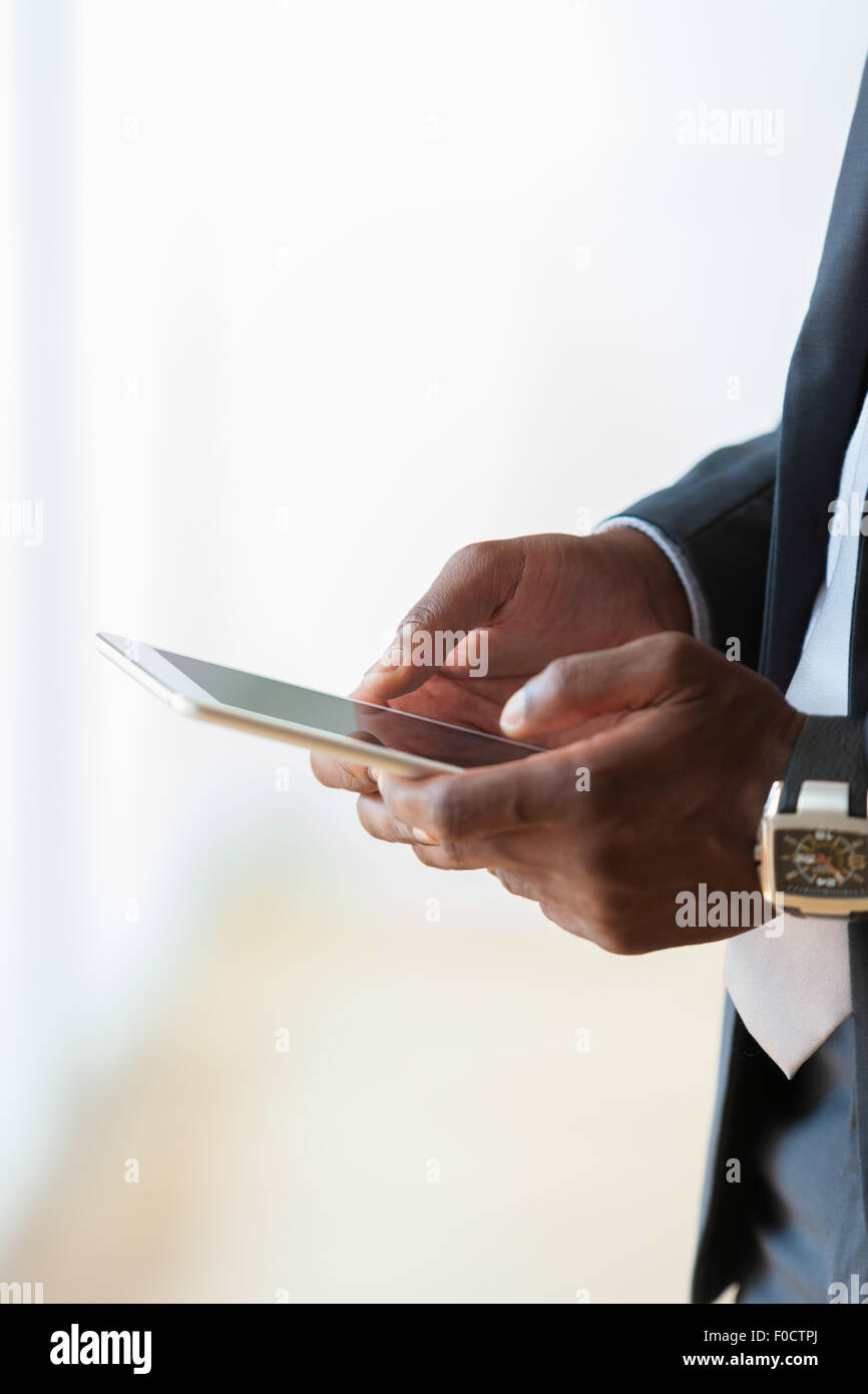 African american business man using a tactile tablet over white ...