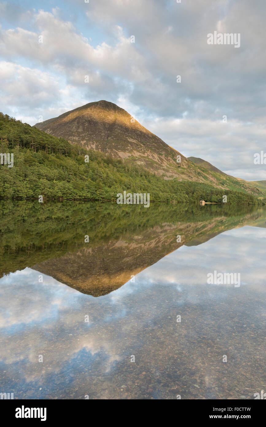 Grasmoor and boat house reflected in Crummock Water in the English Lake District national park Stock Photo