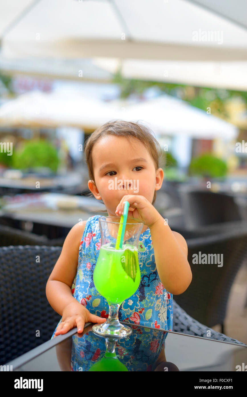 Little girl is drinking  lemonade with mint using straw Stock Photo