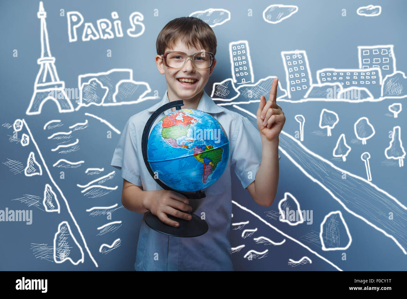 a boy of 10 years of European appearance with glasses holding a globe in hands on a gray  background Stock Photo