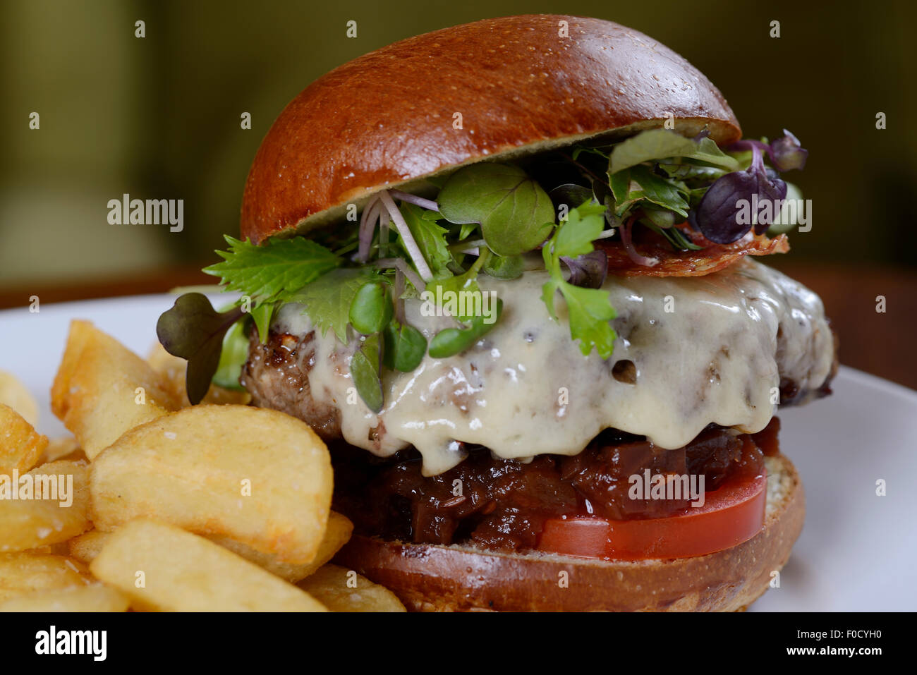 Prime steak burger served with thick cut chips Stock Photo