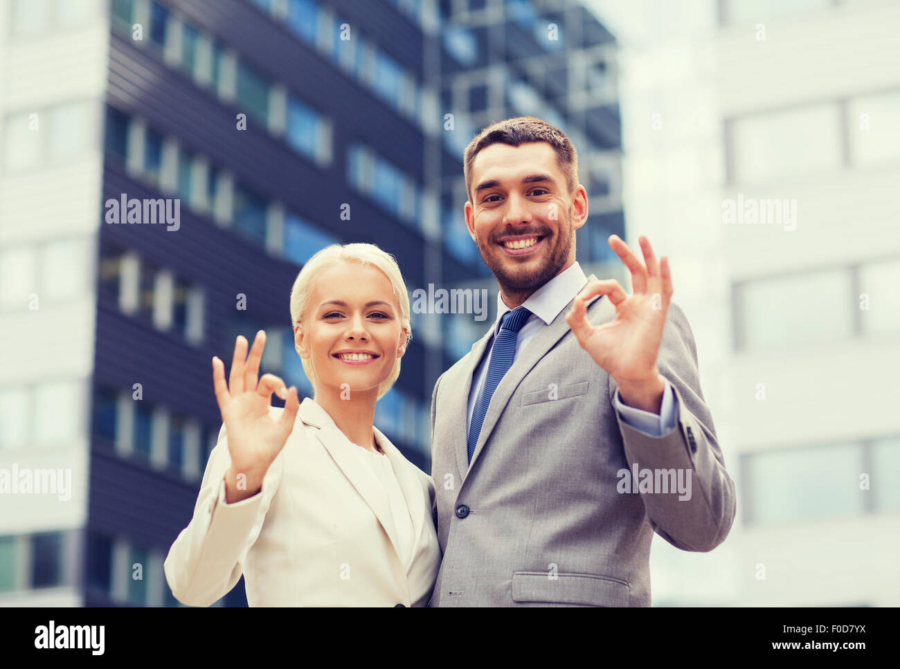 smiling businessmen standing over office building Stock Photo - Alamy