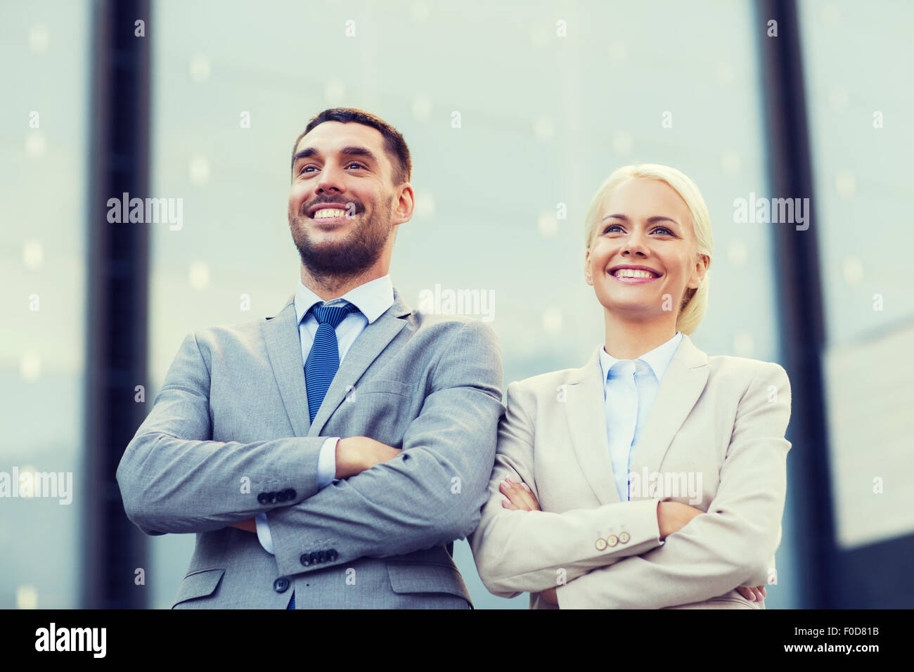 smiling businessmen standing over office building Stock Photo - Alamy