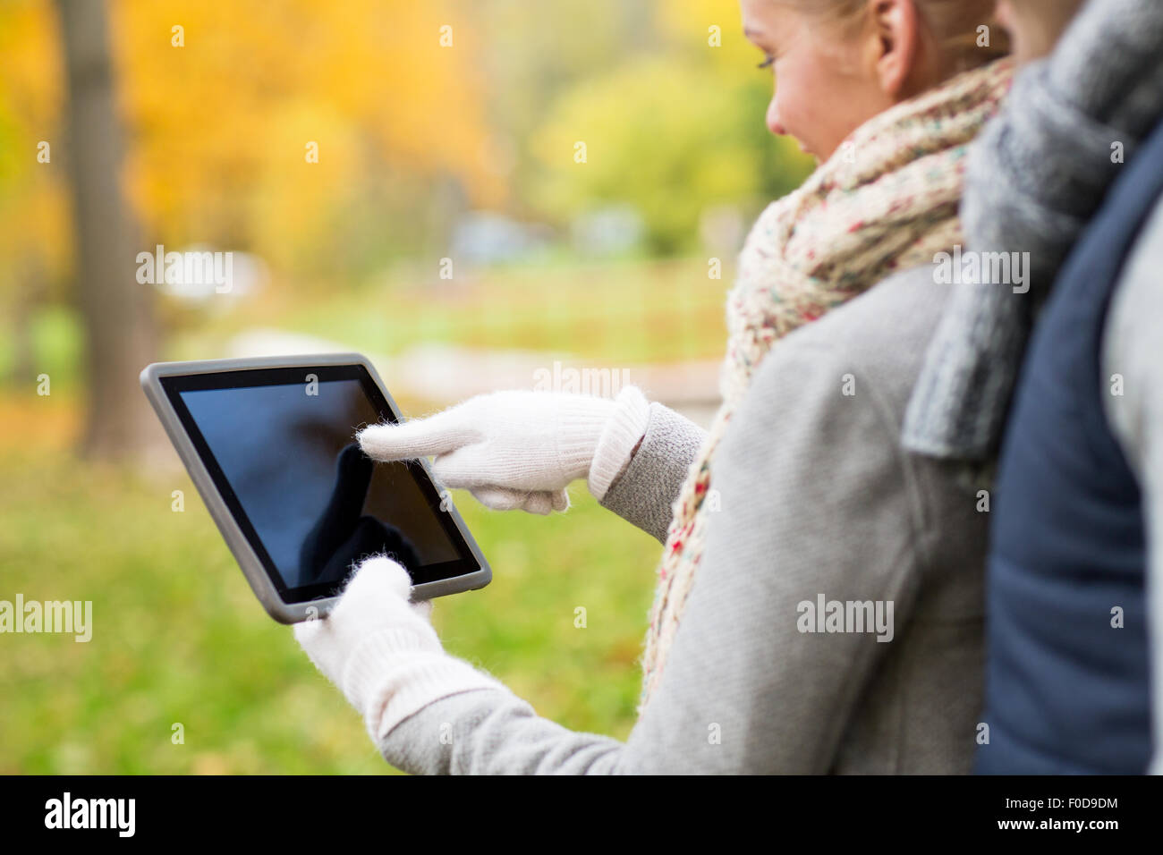 couple hands in gloves with tablet pc outdoors Stock Photo