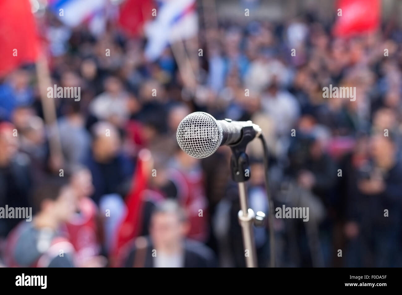 Microphone in focus against blurred audience Stock Photo
