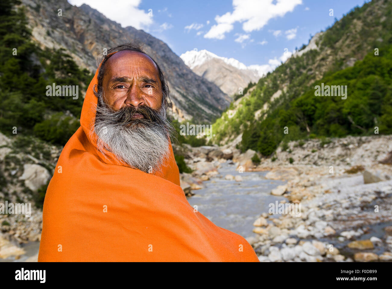 A portrait of Mahant Naomi Giri, a 52 years old Sadhu, sitting at the banks of the holy river Ganges Stock Photo