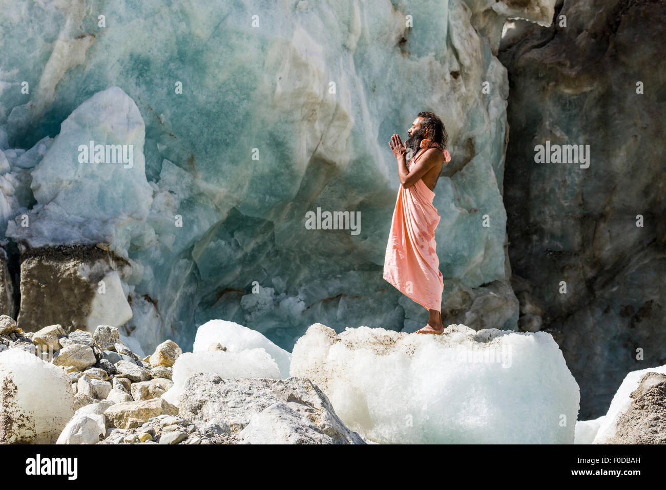 A Sadhu, holy man, is standing and praying on a block of ice at Gaumukh, the main source of the holy river Ganges, Gangotri Stock Photo
