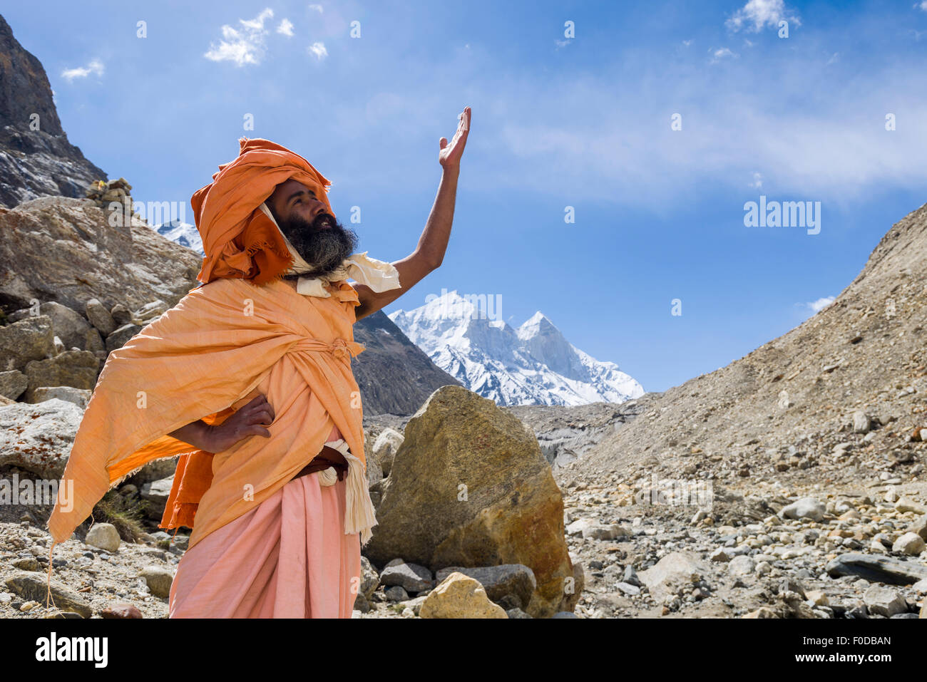 A Sadhu, holy man, is standing and praying at Gaumukh, the main source of the holy river Ganges, Gangotri, Uttarakhand, India Stock Photo