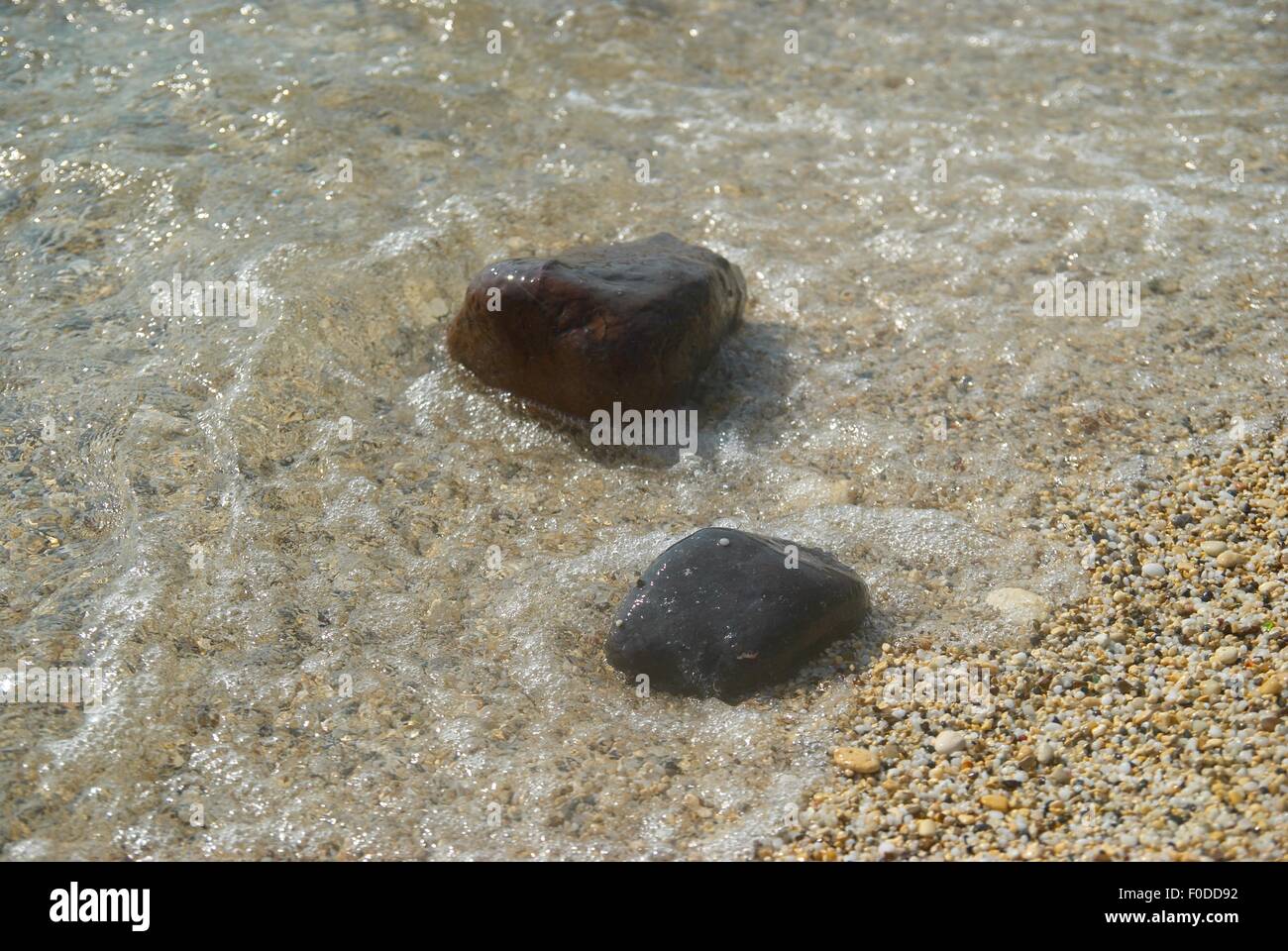 Rocks in the waves and sea foam. Stock Photo