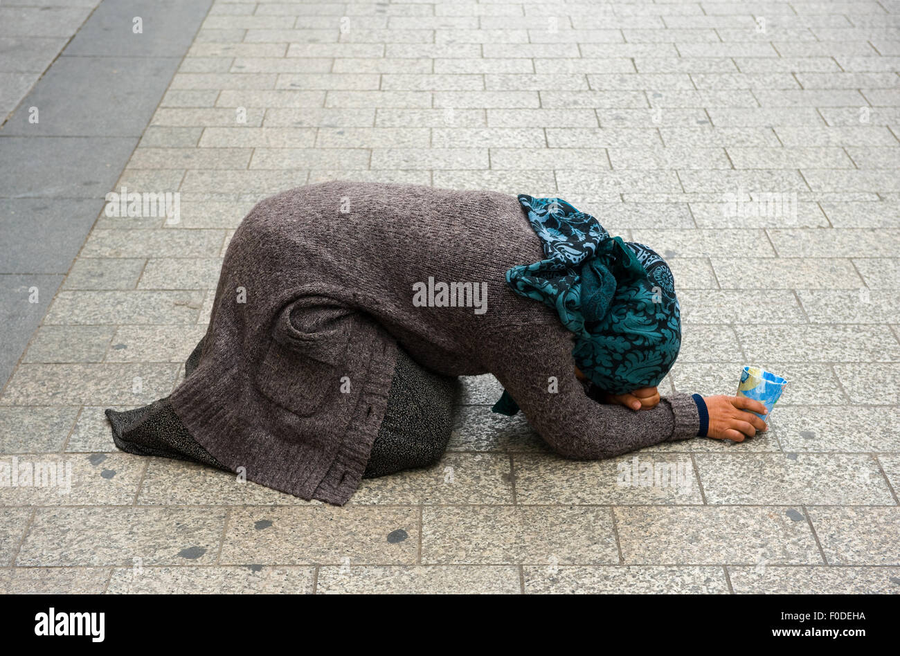 PARIS, FRANCE - JULY 28, 2015: A homeless woman is begging for money on the Champs-Elysees in Paris in France Stock Photo