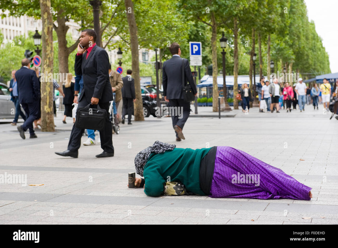 PARIS, FRANCE - JULY 28, 2015: A homeless woman is begging for money on the Champs-Elysees in Paris in France Stock Photo