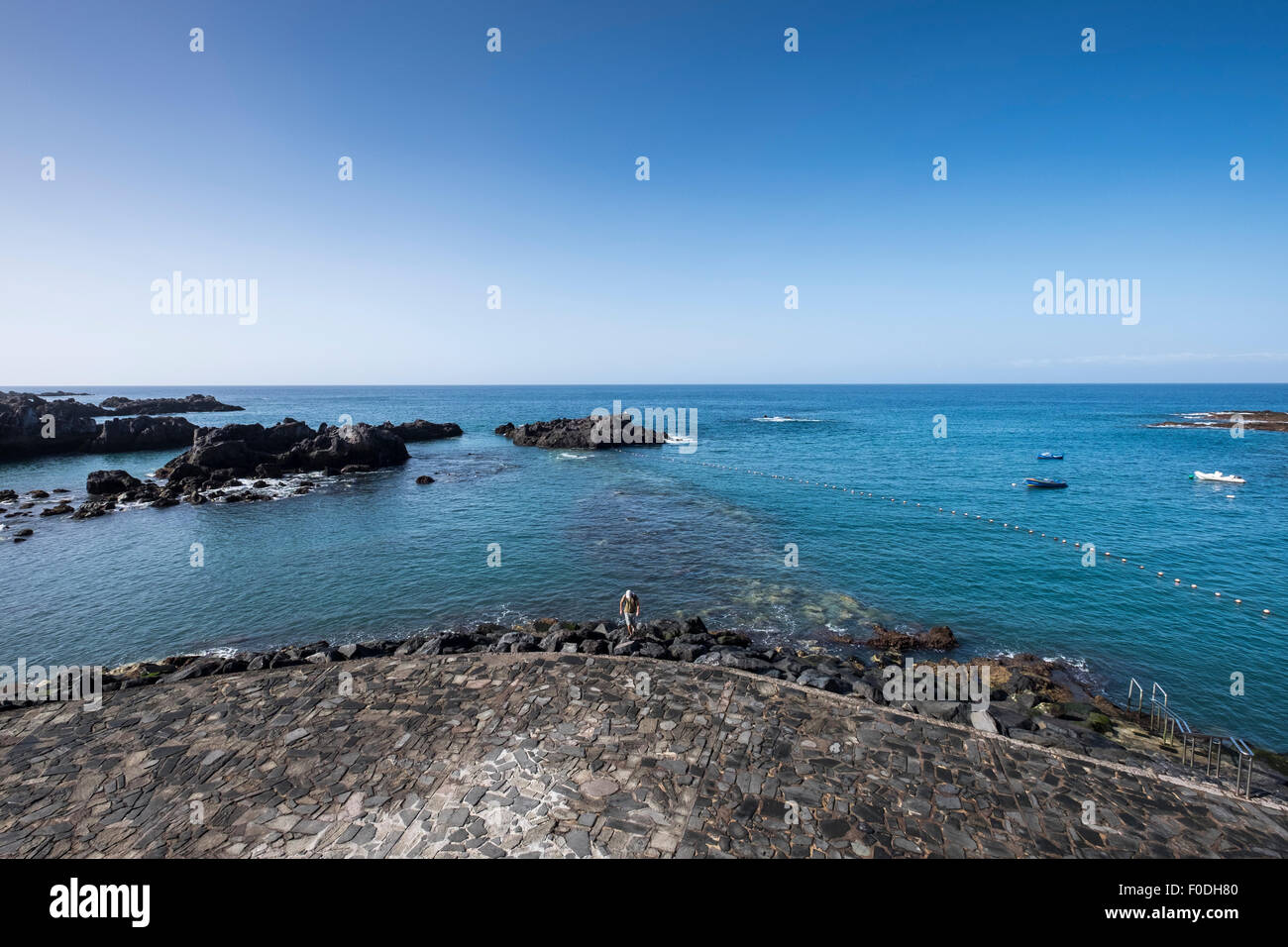 Rocks and crazy paving walkway at Alcala seafront in Guia de Isora, Tenerife, Canary Islands, Spain. Stock Photo
