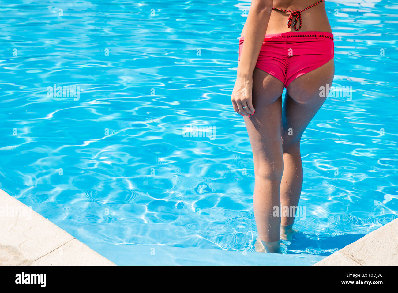Back view portrait of a young woman standing in swimming pool Stock Photo