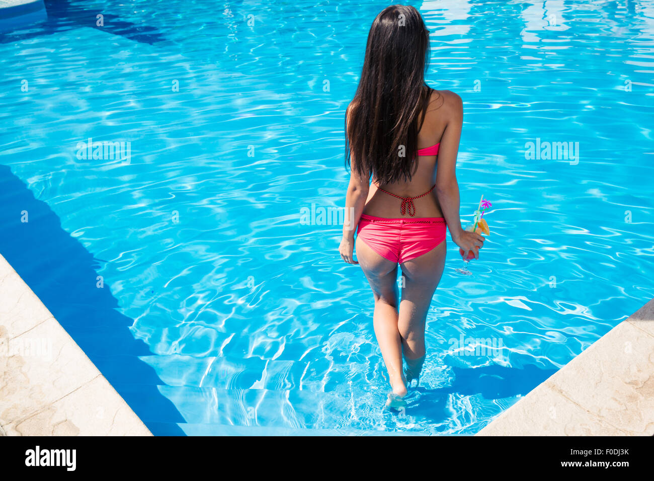 Back view portrait of a woman standing in swimming pool Stock Photo