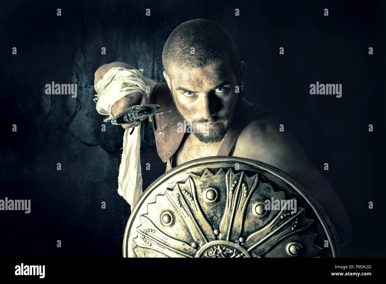 Gladiator posing with shield and sword in a dark background Stock Photo ...
