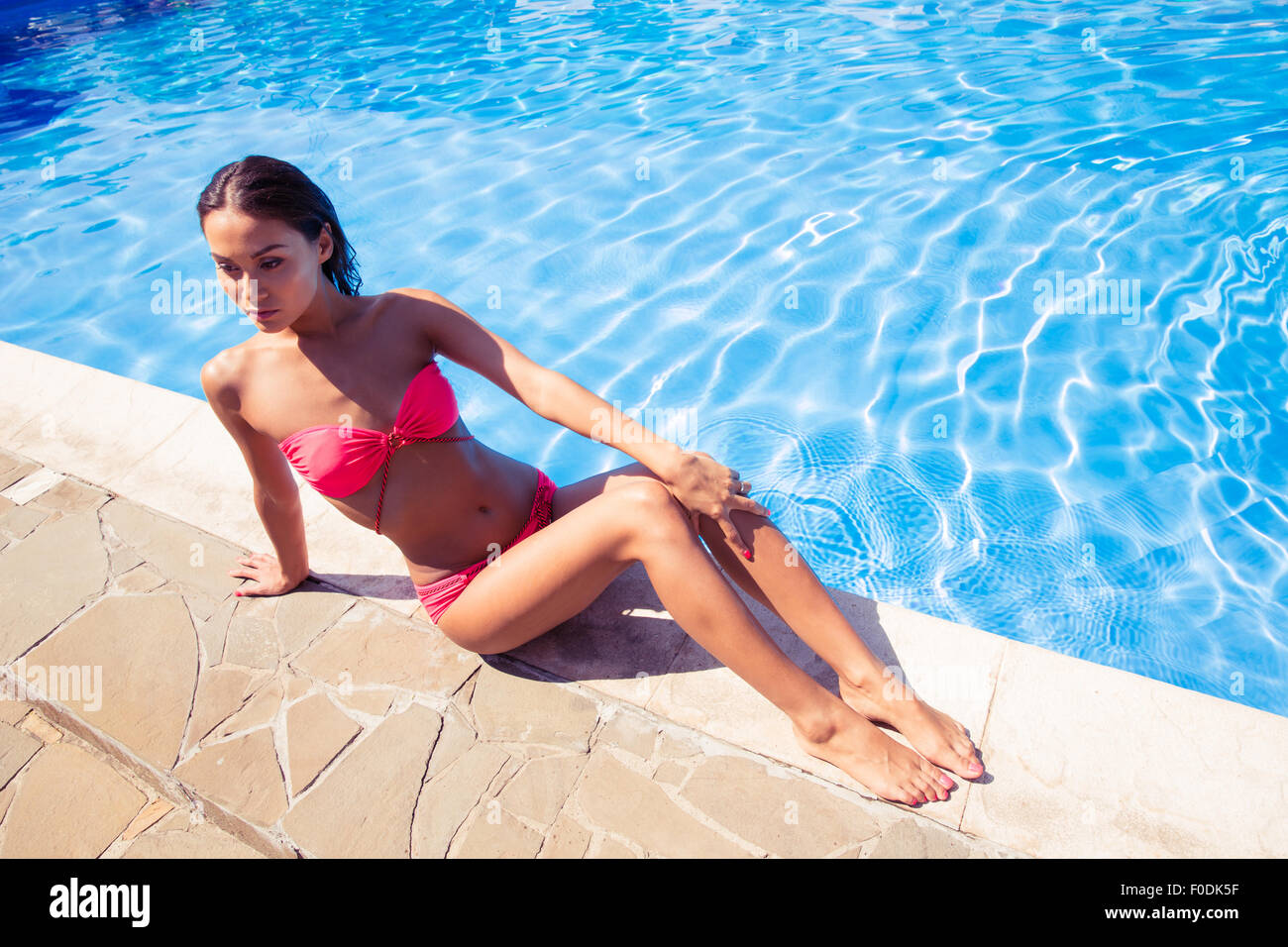 Portrait of a beautiful woman sunbathing near swim pool outdoors Stock