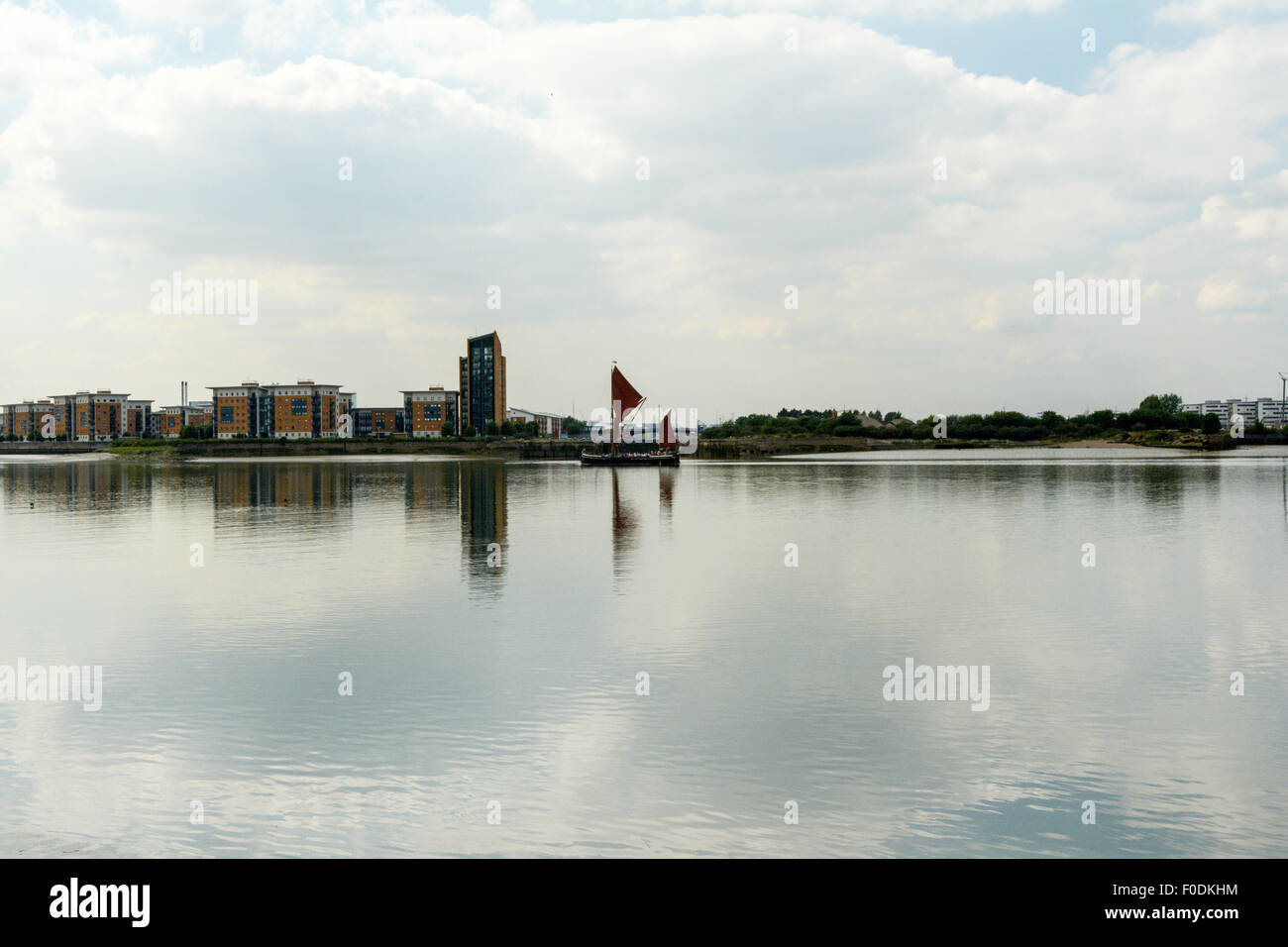 An old Thames Sailing Barge navigates a placid River Thames near the Thames Barrier in London, UK. Stock Photo