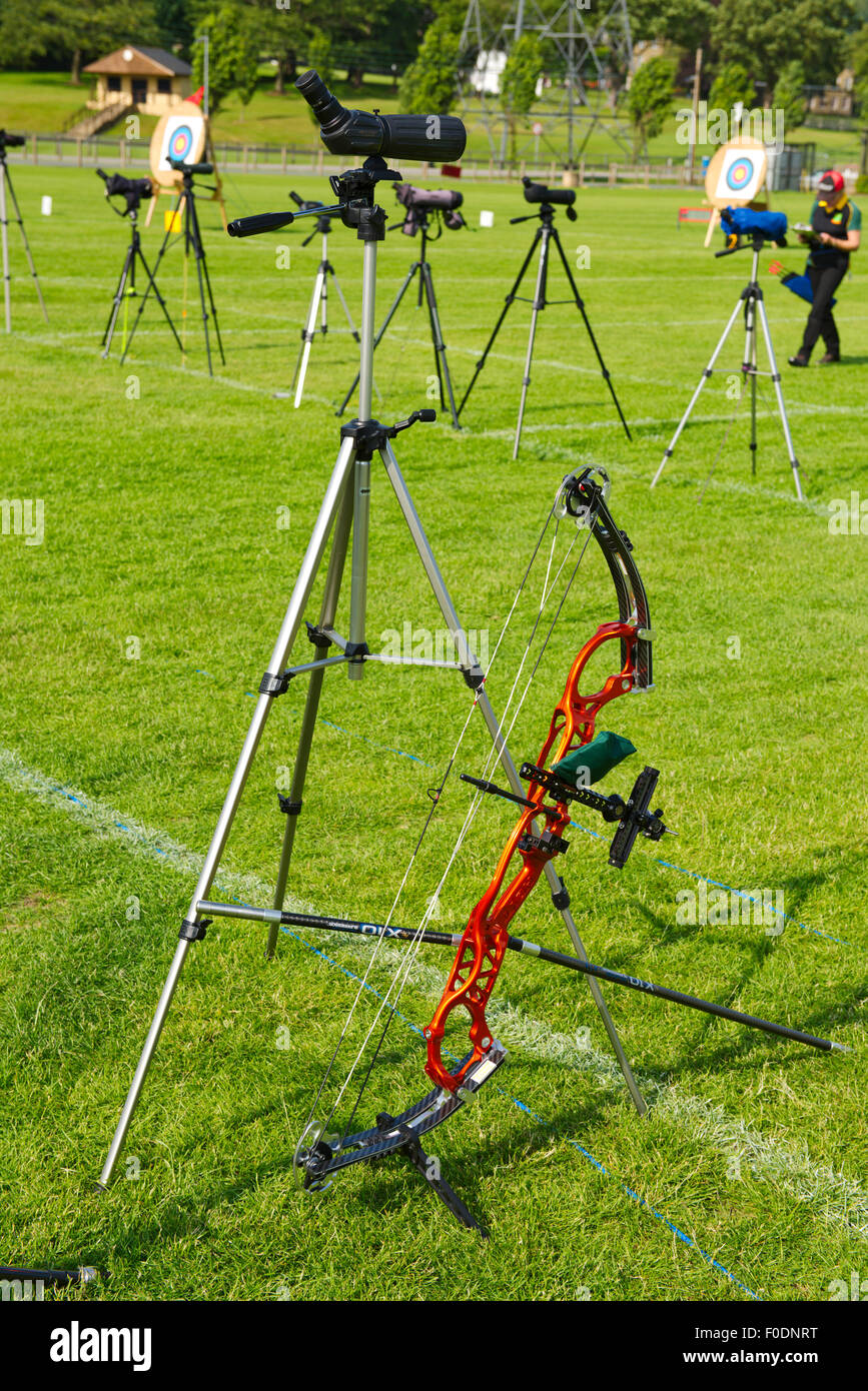 Compound archery bow with sight and stabilizers next to spotting scope at competition Stock Photo