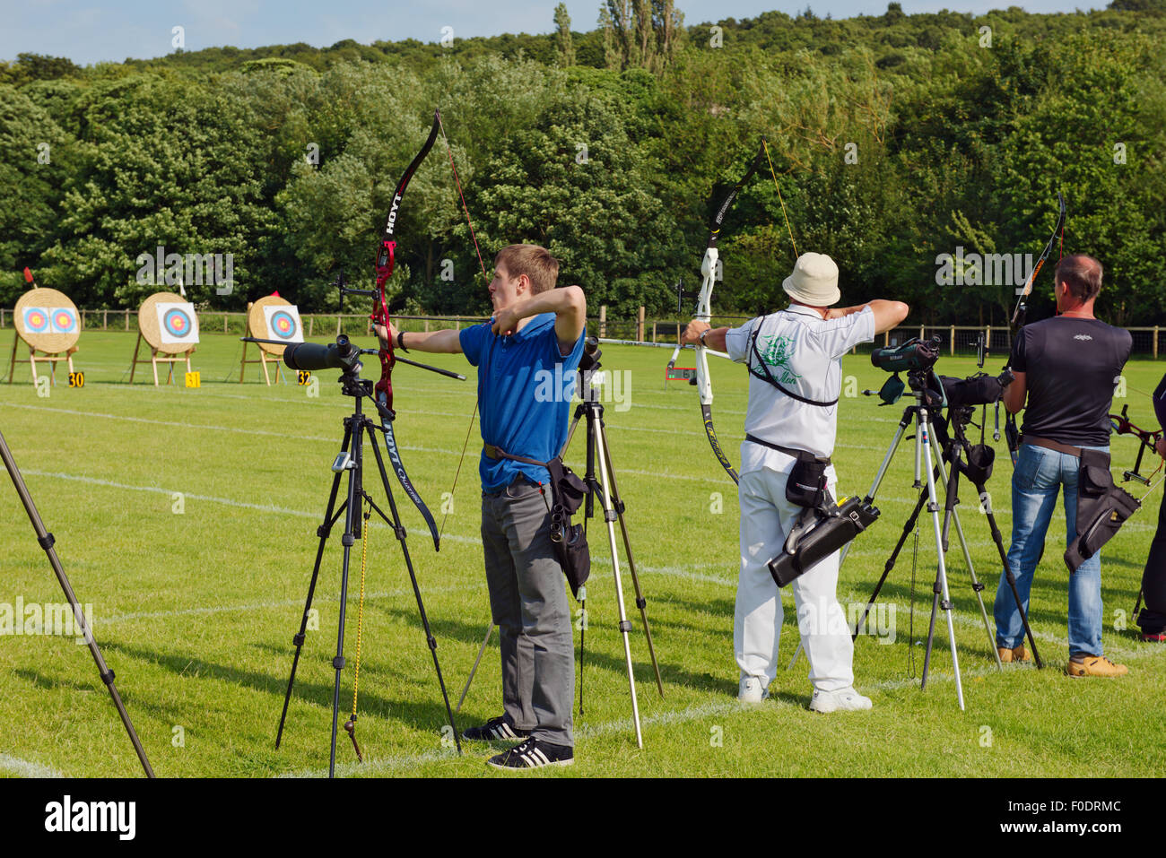 Row of male archers in line shooting recurve style bows in competition, West Yorkshire, England Stock Photo
