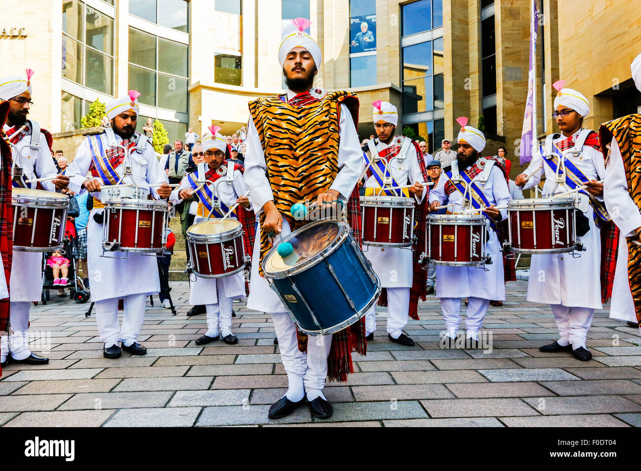 Glasgow, UK. 13th Aug, 2015. At Glasgow's annual Festival of Bagpipe music, 'Piping Live', which ends with the World Championship competition on Saturday 15the August, the National Pipe Band of Malaysia - 'The Sri Dasmesh Pipe Band' based in Kuala Lumpar, entertained the crowds in Buchanan Street and George Square, by playing a medley of Scottish bagpipe music, with beautiful sunshine as well. Credit:  Findlay/Alamy Live News Stock Photo
