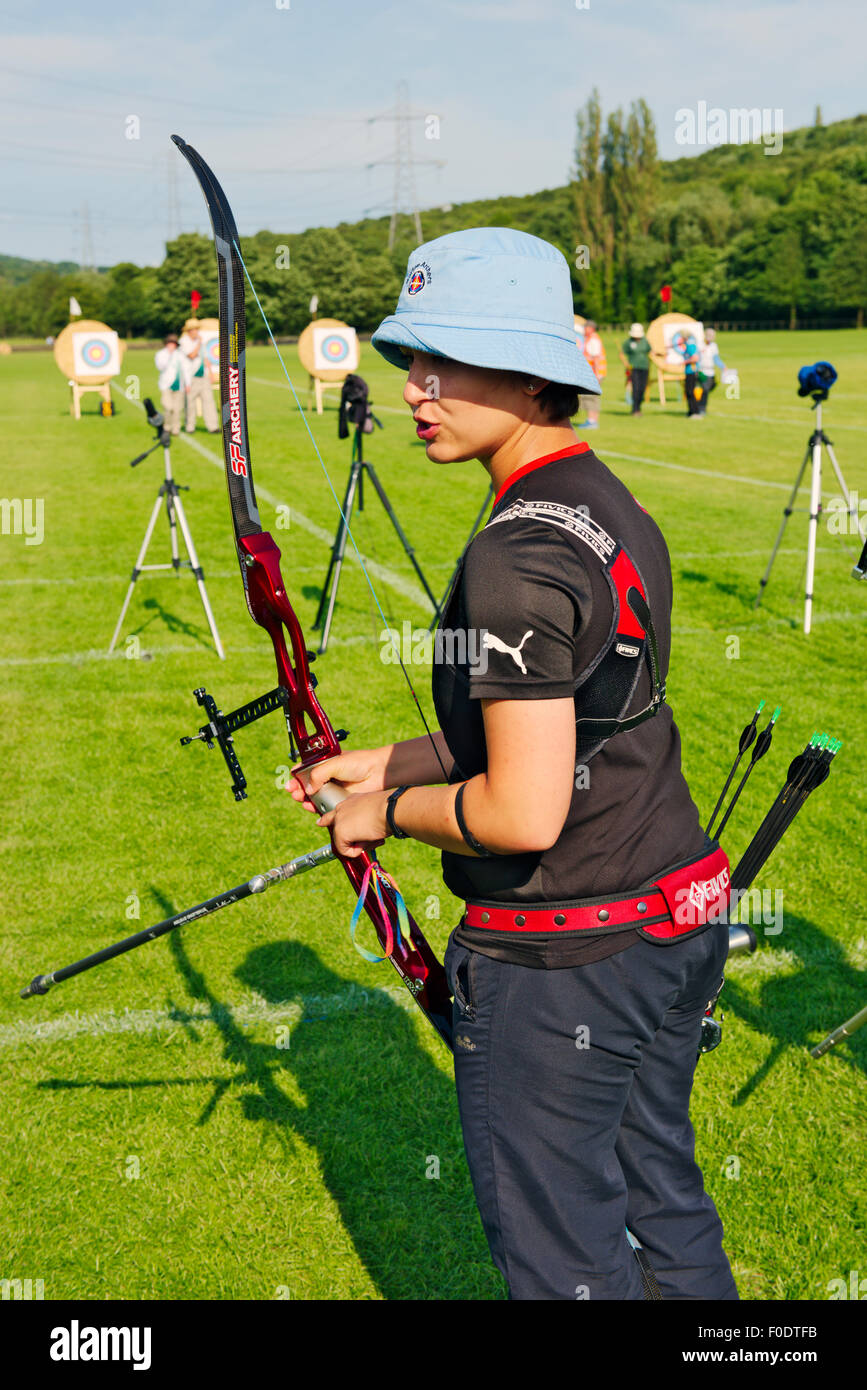 Woman shooting modern recurve bow at target in archery competition, West Yorkshire, England Stock Photo