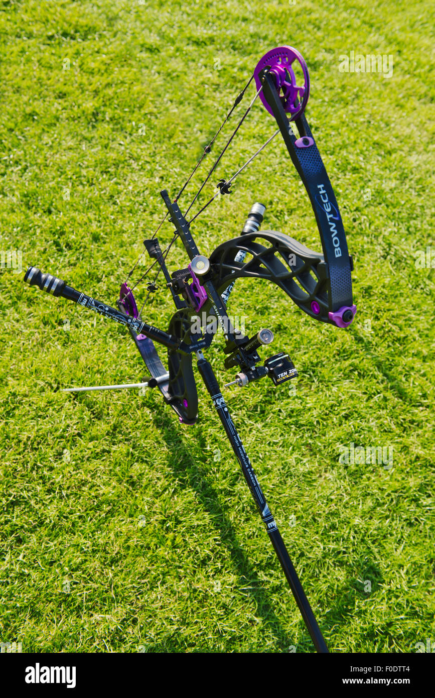 Modern compound archery bow showing eccentric pulleys for levering, the riser and limbs, the sight and stabilizers on stand Stock Photo