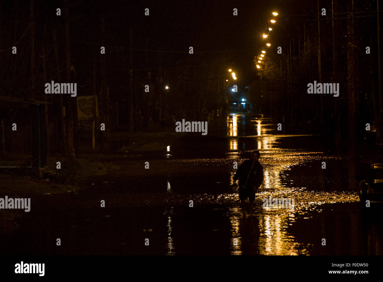 (150813) -- QUILMES, Aug. 13, 2015 (Xinhua) -- A resident walks through flood in Quilmes town, Buenos Aires province, Argentina, during the early hours of Aug. 13, 2015. Argentina's President Cristina Fernandez called on Wednesday to 'double the aid to the affected people by the floods in Buenos Aires province', said the Minister of Economy, Axel Kicillof. The floods left three people dead and some 20,000 evacuated in the past few days in the country, according to local press. (Xinhua/Carlos Brigo/TELAM) Stock Photo