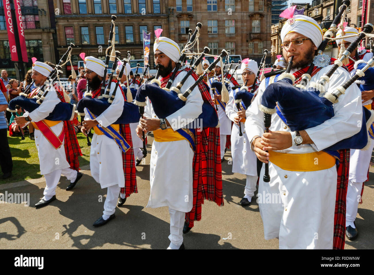 Glasgow, UK, 13th Aug, 2015. At Glasgow's annual Festival of Bagpipe music, 'Piping Live', which ends with the World Championship competition on Saturday 15th August, the National Pipe Band of Malaysia - 'The Sri Dasmesh Pipe Band' based in Kuala Lumpar, entertained the crowds in Buchanan Street and George Square, by playing a medley of Scottish bagpipe music on a sunny day in Scotland. Credit:  Findlay/Alamy Live News Stock Photo