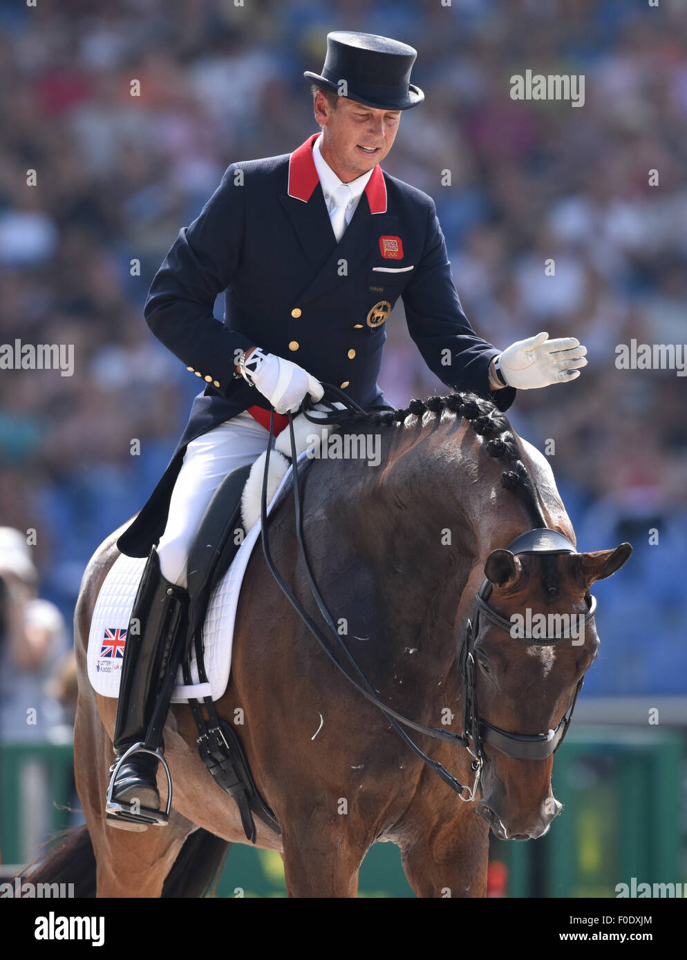 Aachen, Germany. 13th Aug, 2015. Carl Hester of Great Britain gestures on his horse Nip Tuck in the Grand Prix Dressage Team Final during the FEI European Championships in Aachen, Germany, 13 August 2015. Photo: Uwe Anspach/dpa/Alamy Live News Stock Photo