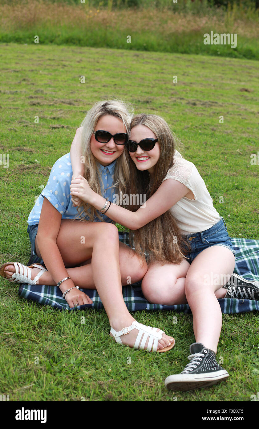 Two teenage girls outdoors with their arms around each other Stock ...