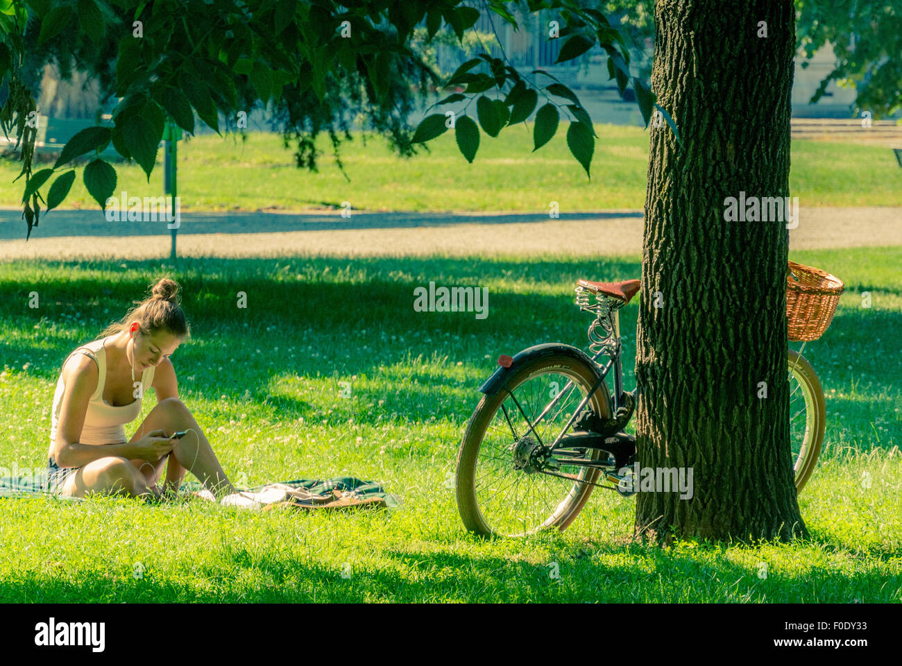 Girl listening to MP3 player in Montanelli Park, Milan Stock Photo