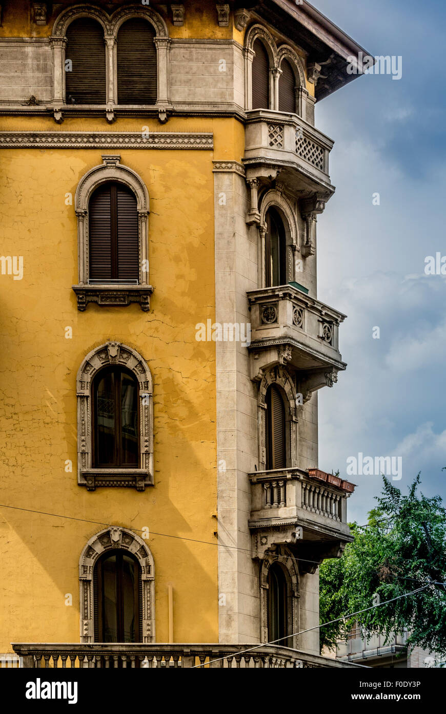 Yellow rendered building with arched windows. Stock Photo