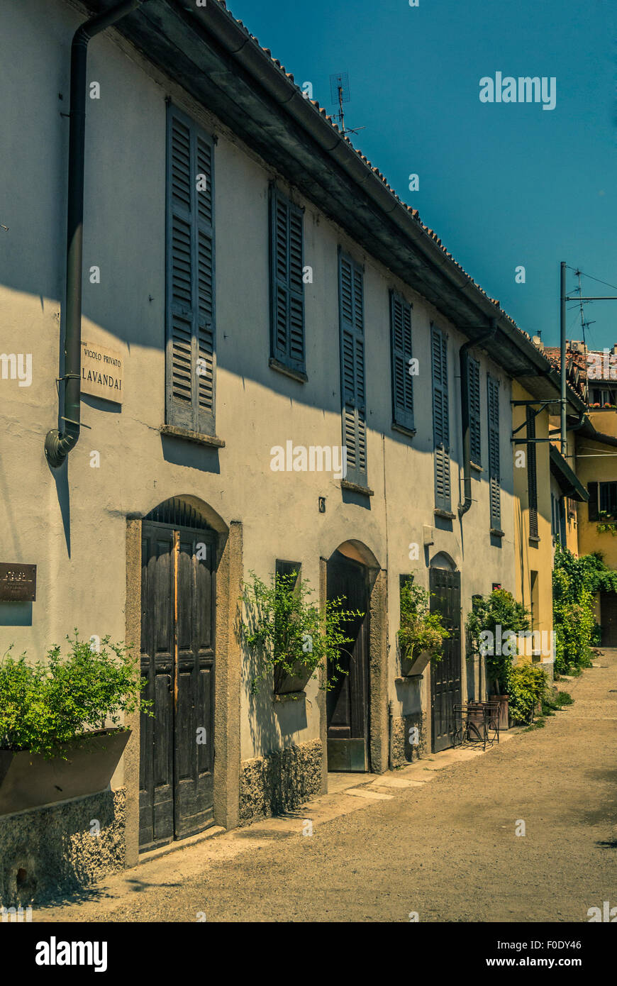 White rendered buildings with wooden doors. Naviglio, Milan, Italy ...