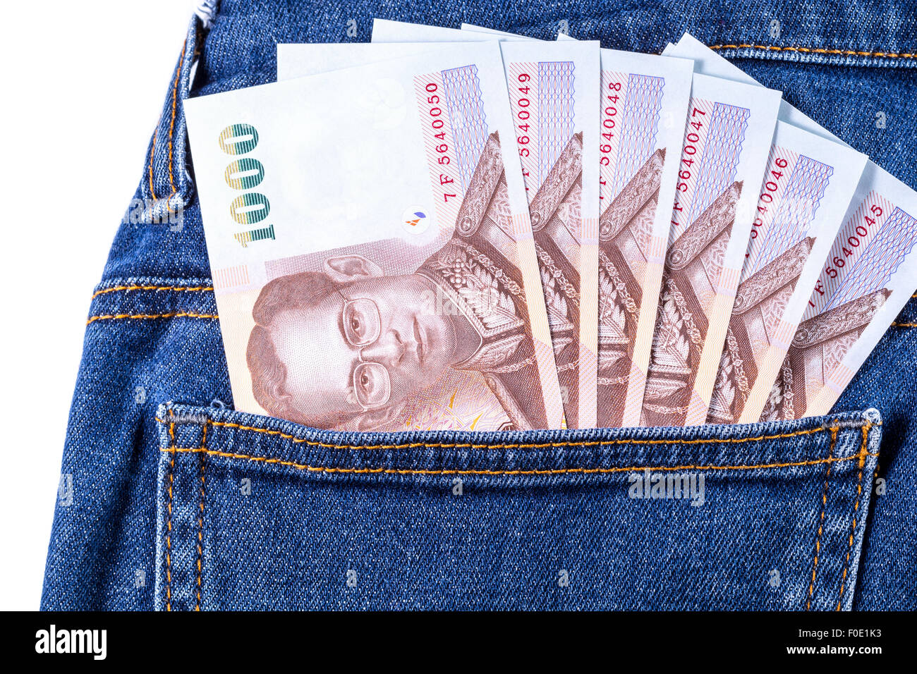 Thai Money 1000 Bath on blue jeans isolated on white background Stock Photo
