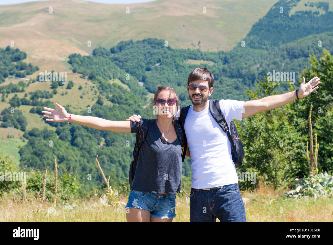 Happy couple on a hiking trip surrounded by mountains. Couples hiking Stock Photo